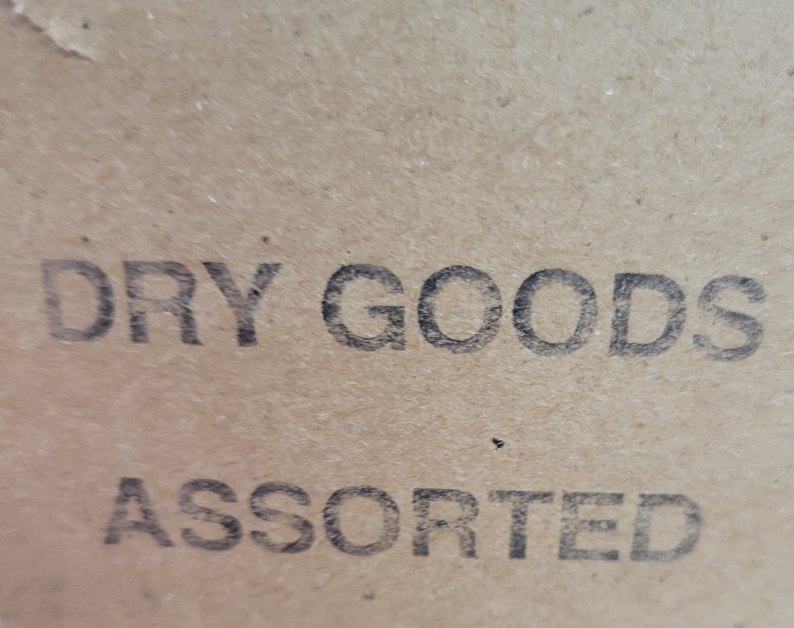 Stamped cardboard that says dry goods assorted.